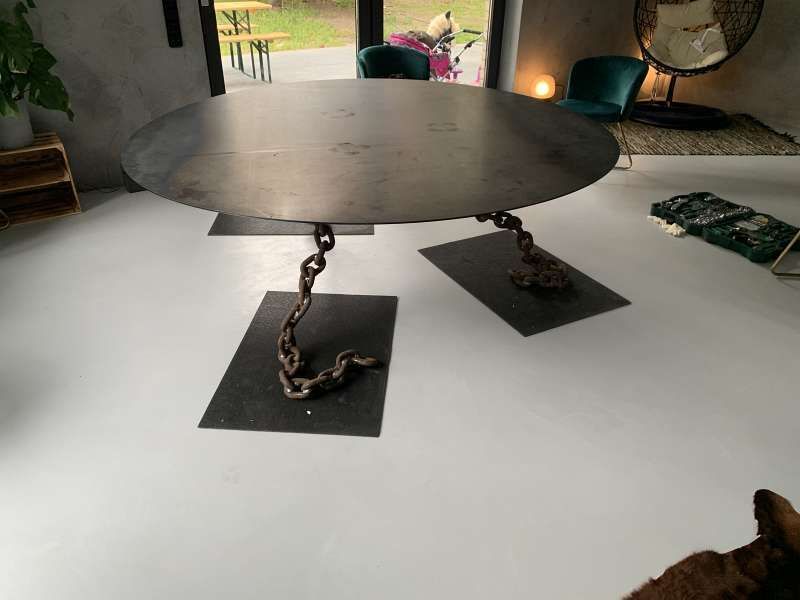 Ein runder Tisch mit einer Kette darum in einem Wohnzimmer.