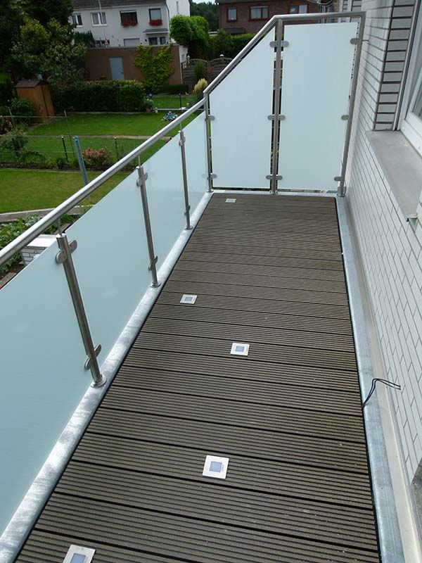 Ein Balkon mit Holzdeck und Edelstahlgeländer