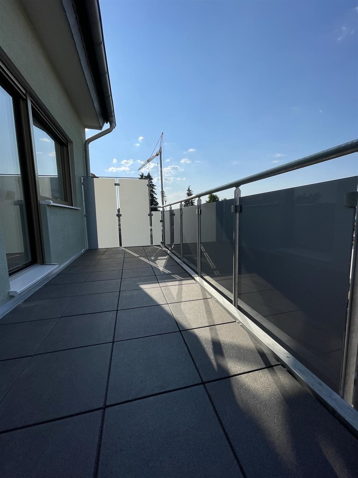 Ein Balkon mit Edelstahlgeländer und Fliesenboden