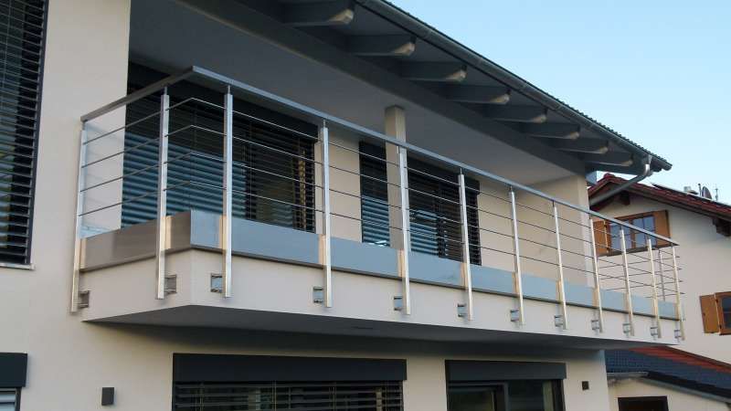Ein Balkon an der Seite eines Hauses mit einem Edelstahlgeländer
