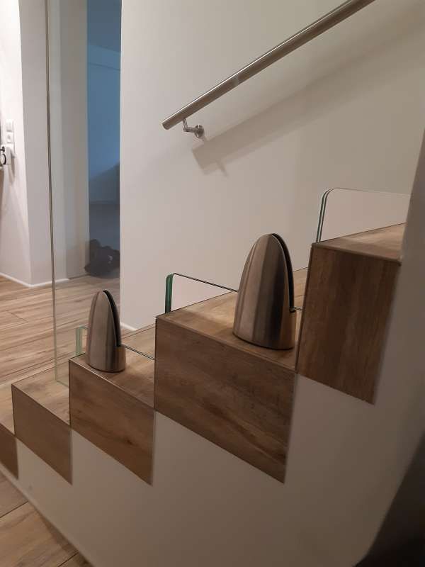 Eine Treppe mit Holzstufen und einem Glasgeländer.