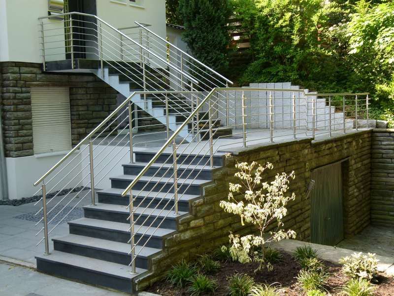 Eine Treppe, die zu einem Haus mit einem Edelstahlgeländer führt