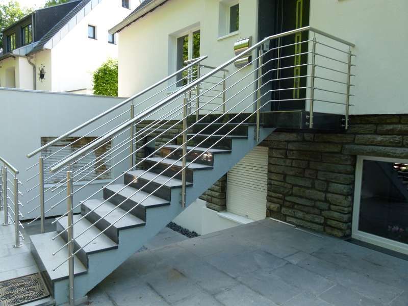 Eine Treppe, die zu einem Haus mit einem Edelstahlgeländer führt