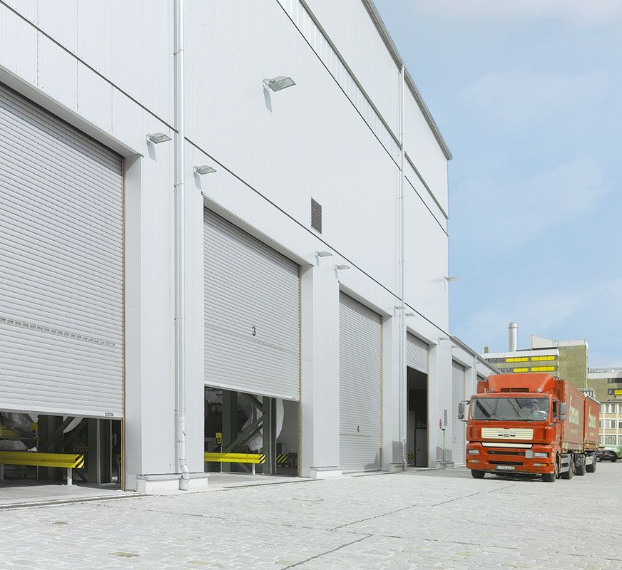 Ein roter LKW steht vor einem weißen Gebäude