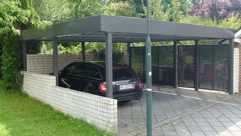 Ein schwarzes Auto ist in einem Carport geparkt.