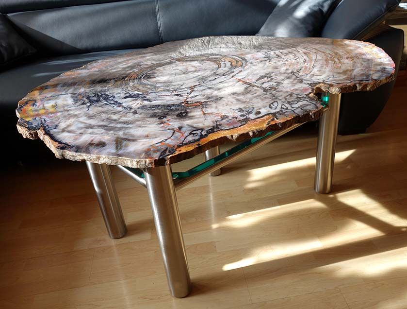 In einem Wohnzimmer steht ein Holztisch vor einem Sofa.