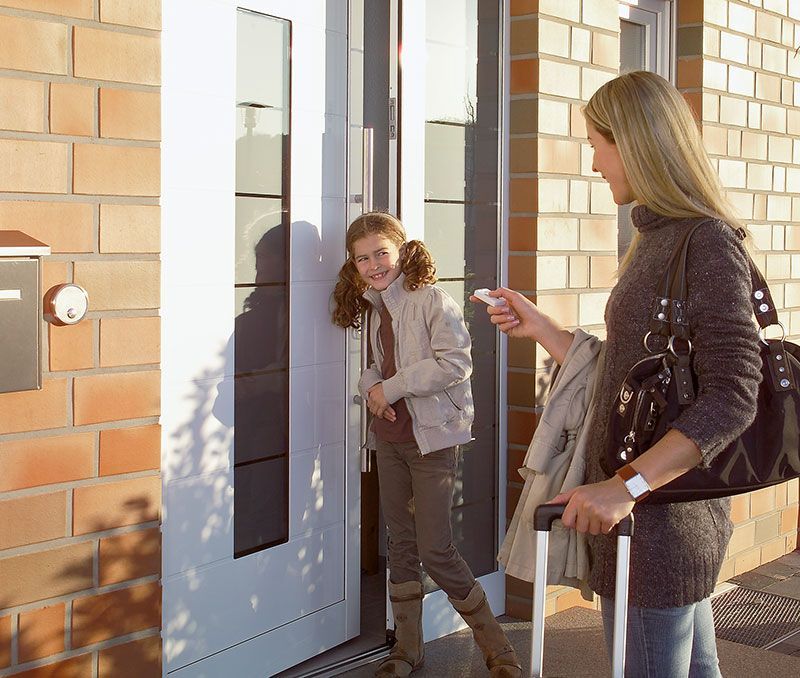 Eine Frau und ein kleines Mädchen stehen vor einer Tür