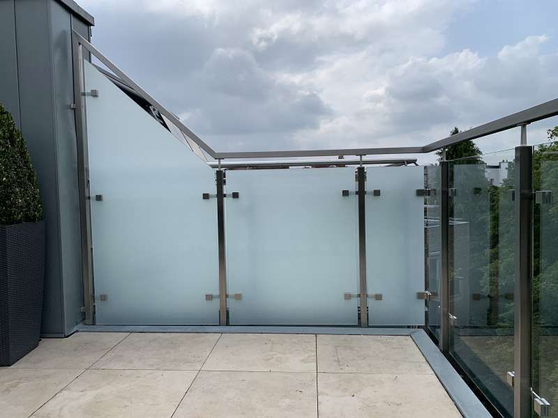 Ein Balkon mit Edelstahlgeländer und Milchglas