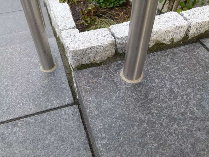 Eine Nahaufnahme eines Edelstahlgeländers auf einer Terrasse.