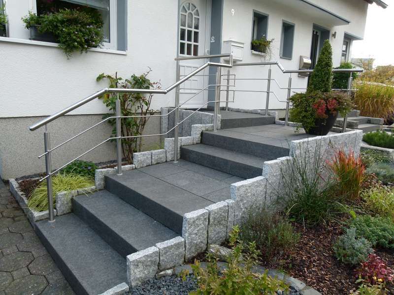 Eine Treppe, die zu einem Haus mit einem Edelstahlgeländer führt