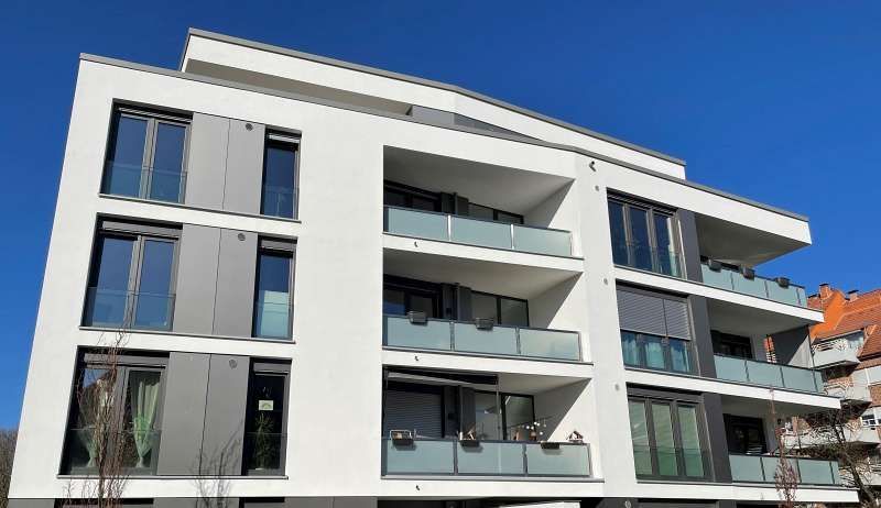 Ein großes Mehrfamilienhaus mit vielen Fenstern und Balkonen