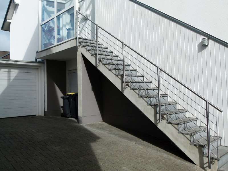 Eine Treppe, die zu einer Garage mit einem Edelstahlgeländer führt
