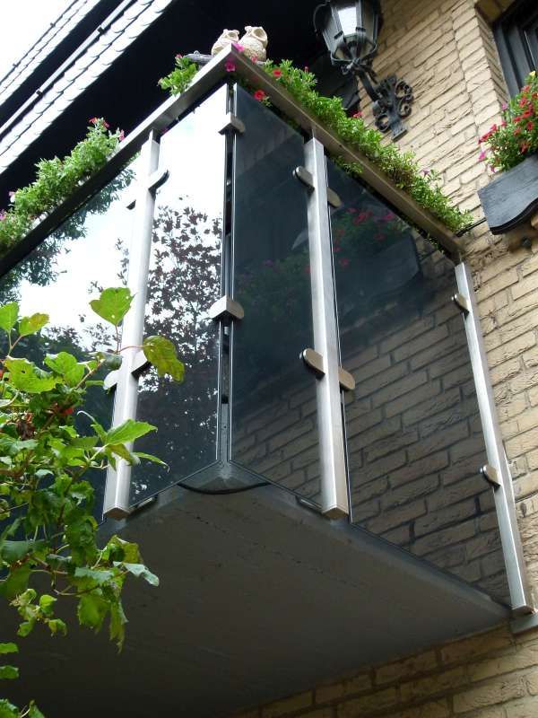 Ein Backsteingebäude mit einem Balkon mit Blumen darauf