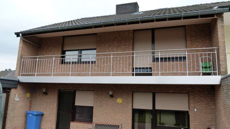 Ein Backsteinhaus mit Balkon und Fensterläden