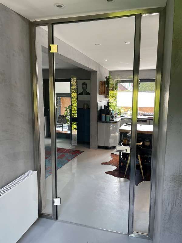 Eine Edelstahltür öffnet sich zum Wohnzimmer und zur Küche.