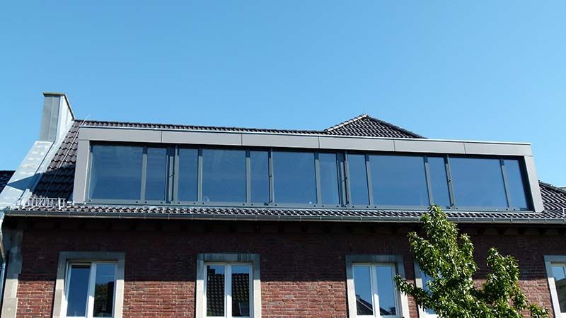 Ein Backsteingebäude mit einem großen Fenster auf dem Dach