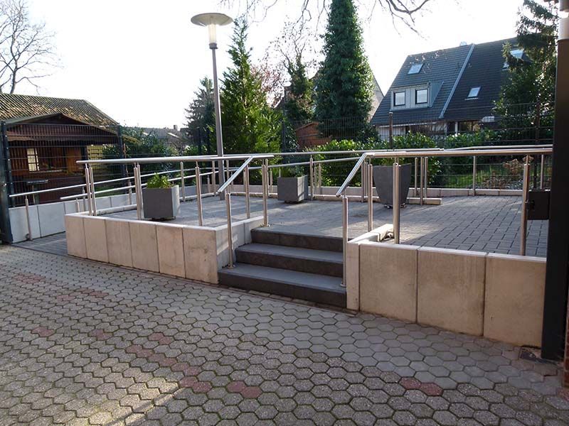 Ein gemauerter Gehweg mit Treppen und Geländer