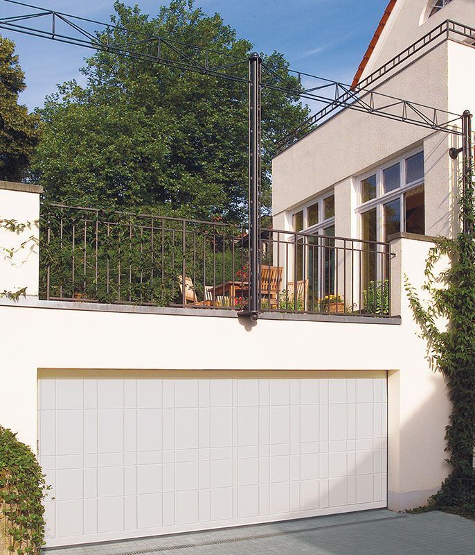Ein weißes Garagentor mit einem Balkon darüber