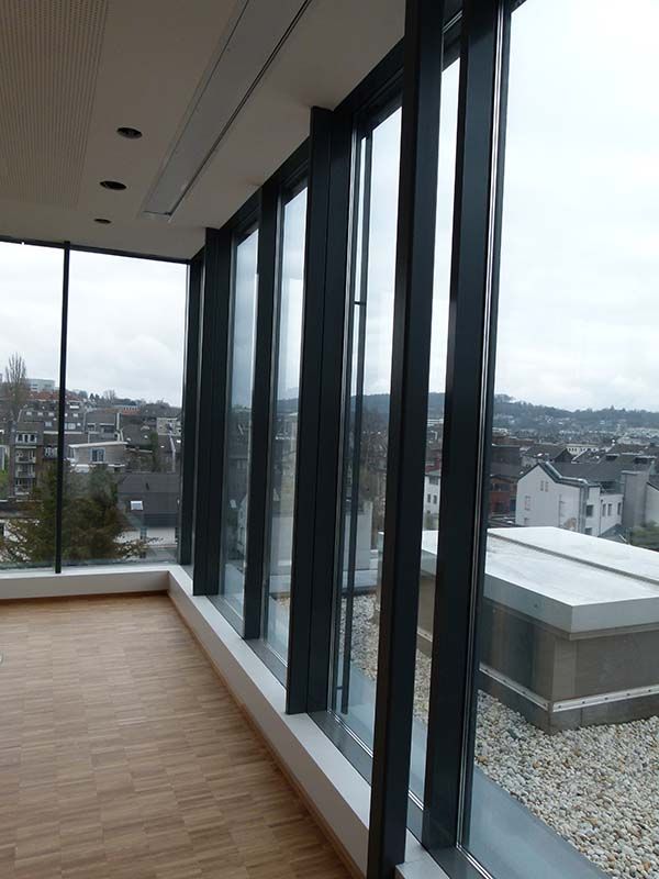 Ein Raum mit vielen Fenstern und Blick auf die Stadt