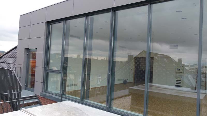 Ein Gebäude mit vielen Fenstern und einem Balkon.