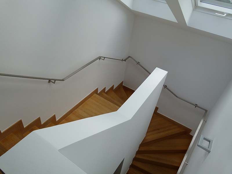 Eine Treppe mit weißem Geländer und Holzstufen