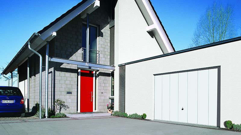 Ein Auto steht vor einem Haus mit einer roten Tür