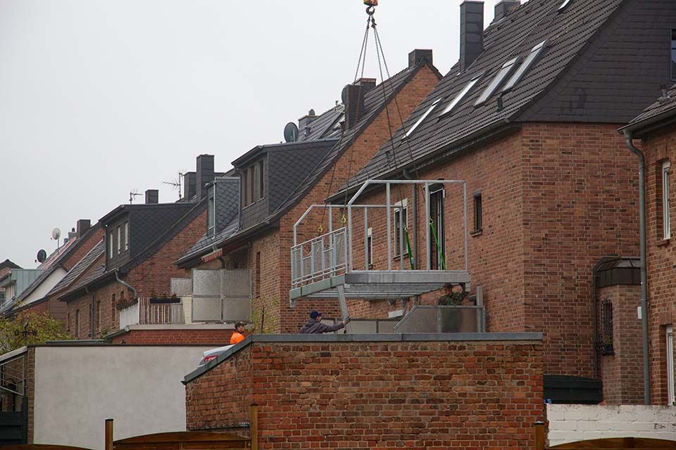Eine Reihe von Backsteinhäusern mit einem Kran im Hintergrund.