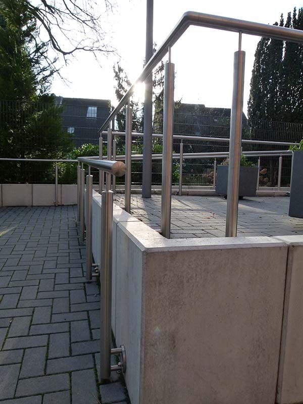 Ein gemauerter Gehweg mit einem Geländer aus Edelstahl