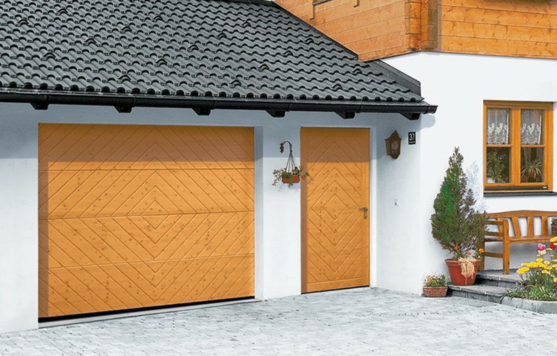 Ein weißes Haus mit einem hölzernen Garagentor