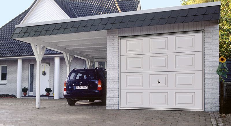 Ein Auto ist unter einem weißen Garagentor geparkt