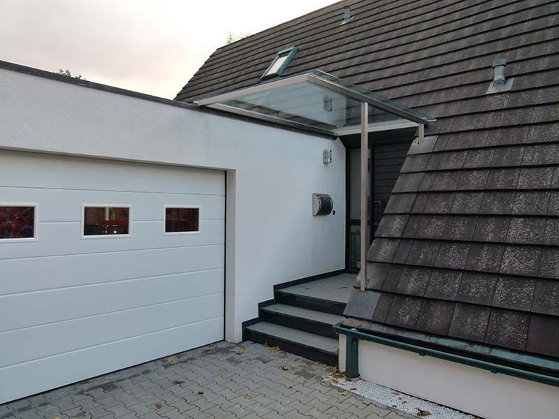 Ein weißes Garagentor mit einem Glasdach darüber