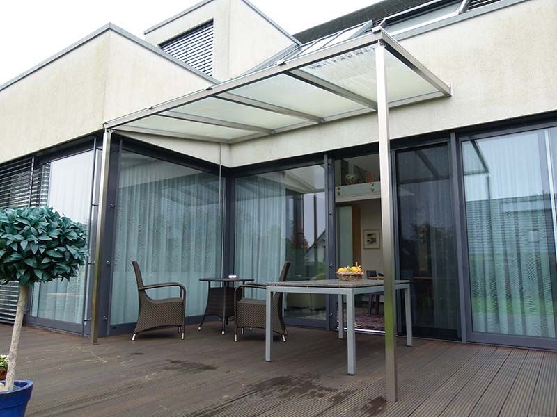 Eine Terrasse mit Tisch und Stühlen unter einem Baldachin