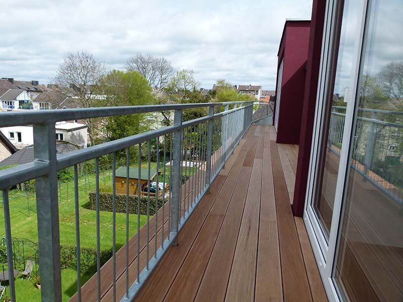 Ein Balkon mit Metallgeländer und Holzterrasse