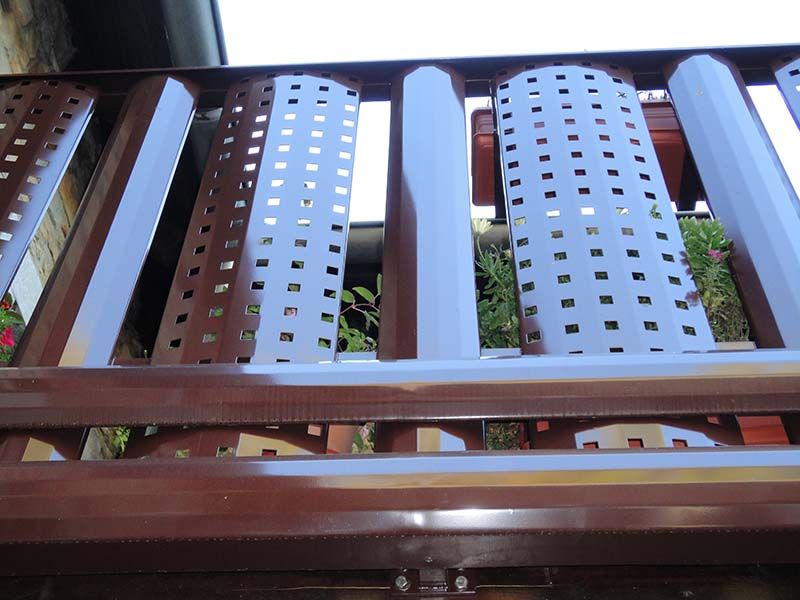 Eine Nahaufnahme eines Metallgeländers mit Löchern darin