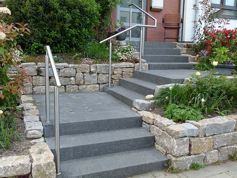 Eine Treppe, die zu einem Haus mit einem Edelstahlgeländer führt