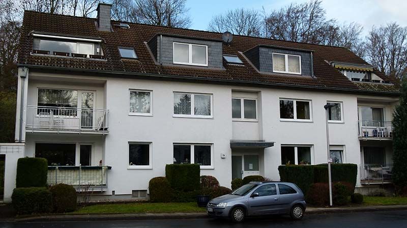 Ein weißes Gebäude mit einem davor geparkten Auto