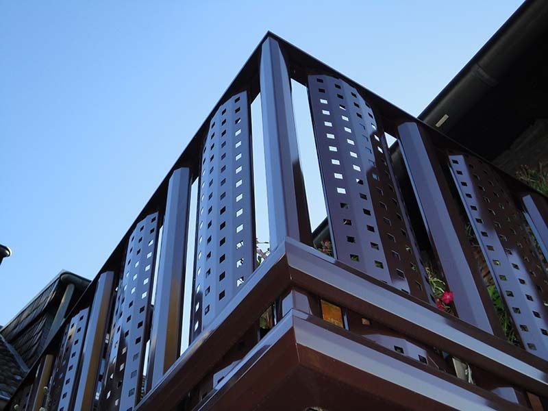 Ein Balkon an der Seite eines Gebäudes mit einem blauen Himmel im Hintergrund