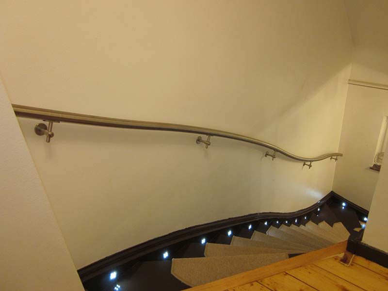 Eine Treppe mit Handlauf und Beleuchtung auf den Stufen