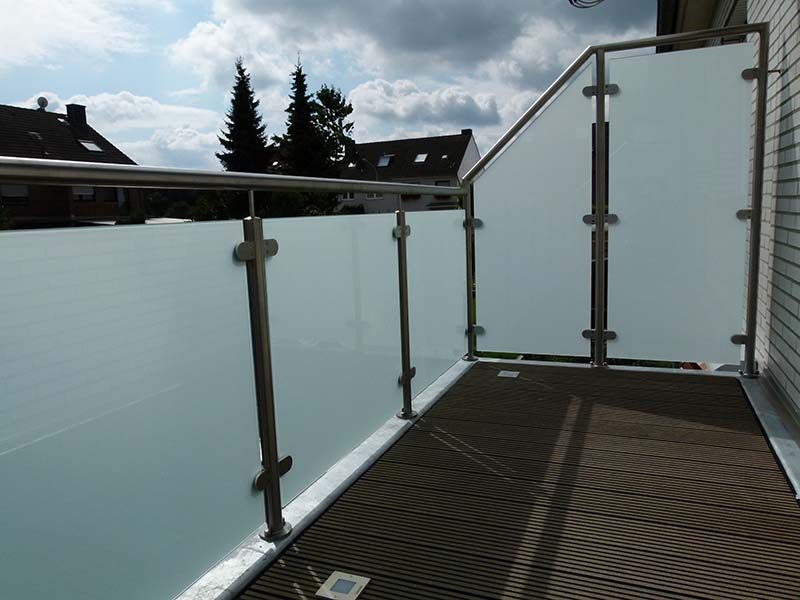 Ein Balkon mit Edelstahlgeländer und Milchglas