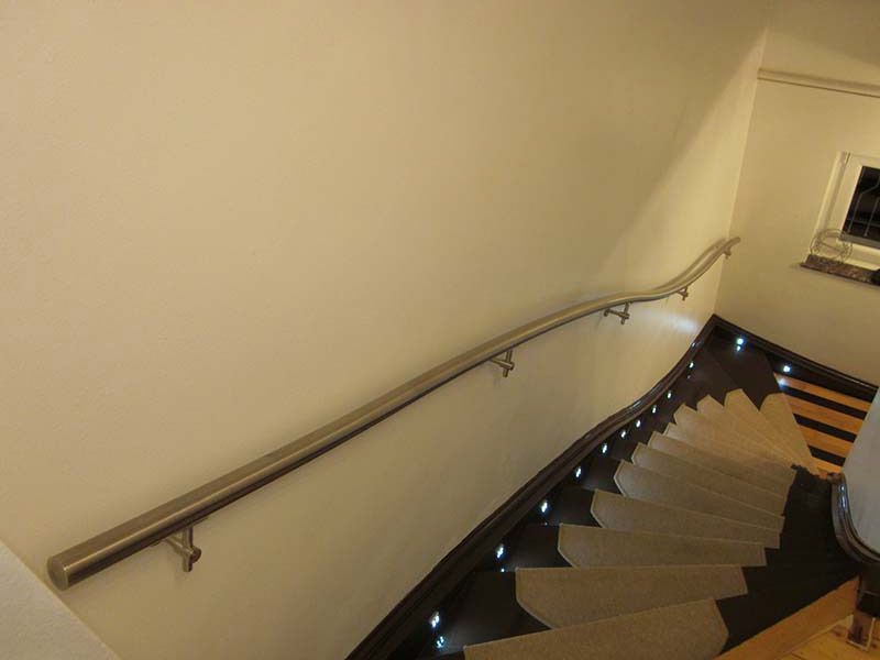 Eine Treppe mit Edelstahlgeländer und Beleuchtung auf den Stufen