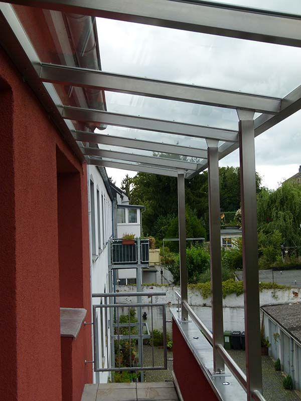Ein Balkon mit Edelstahlgeländer und Glasdach