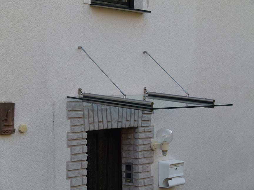 Ein weißes Gebäude mit einem Glasdach über der Tür