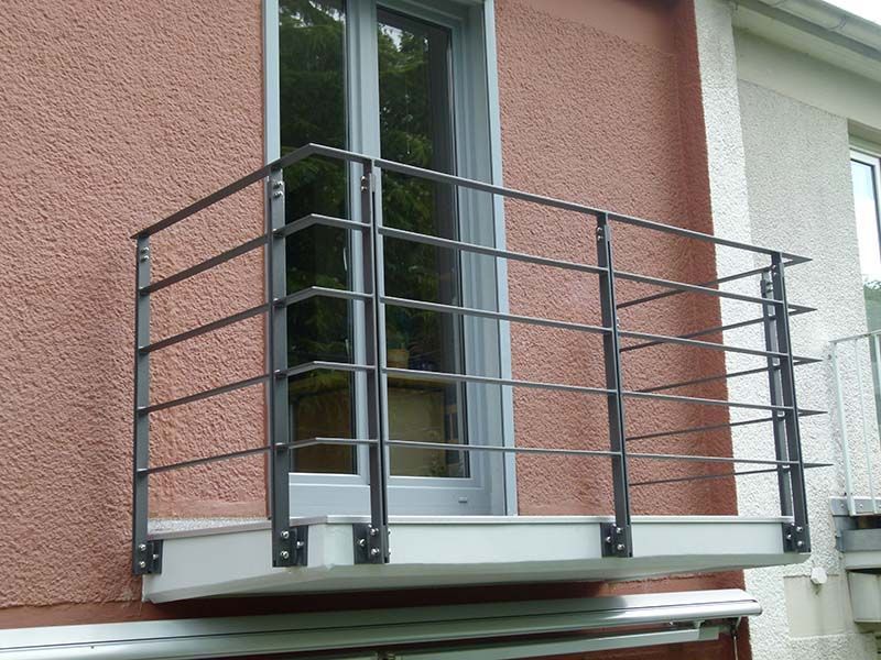 Ein Balkon mit einem Metallgeländer an der Seite eines Gebäudes