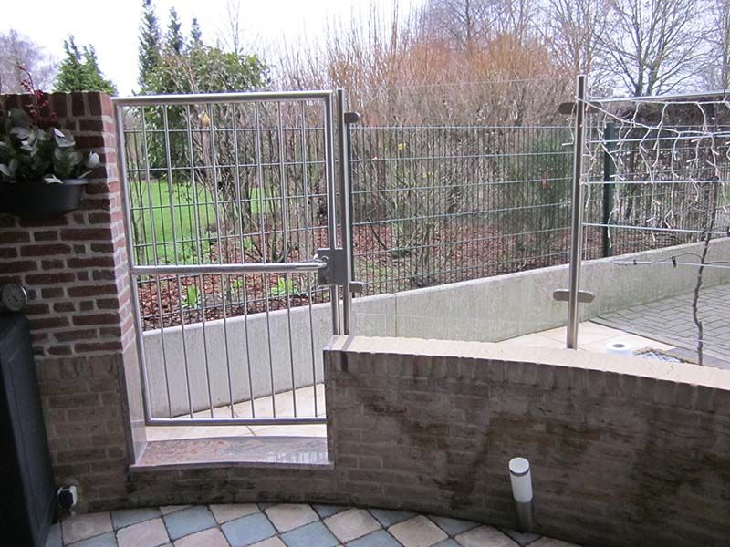 Ein Metalltor ist zu einer Ziegelmauer hin offen