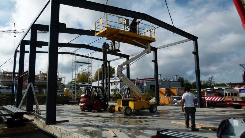 Ein Mann steht vor einem im Bau befindlichen Gebäude.