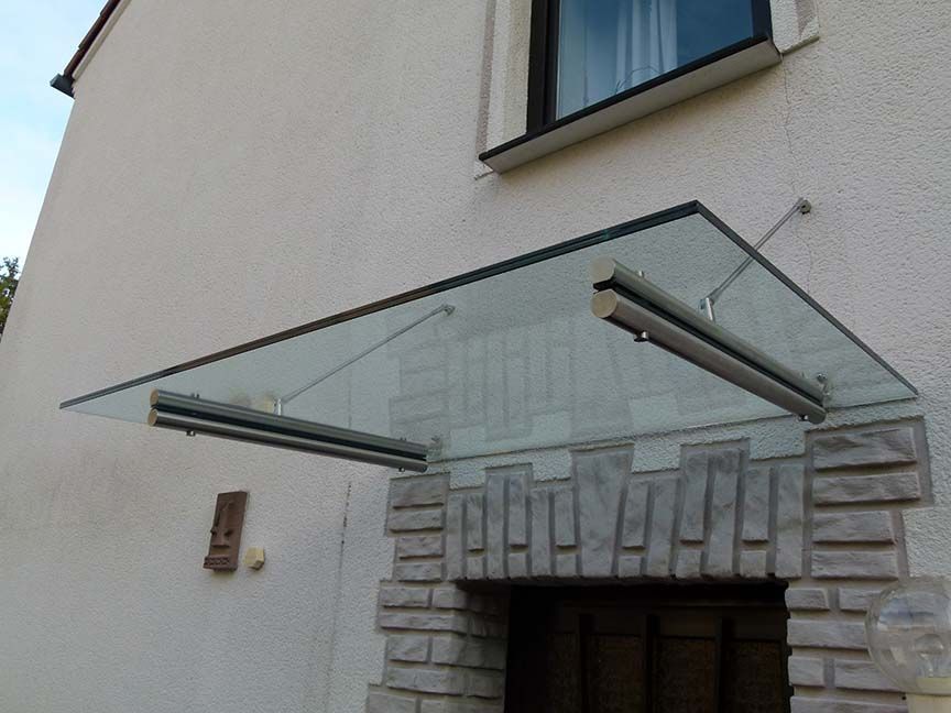 Ein weißes Gebäude mit einem Glasdach über der Tür