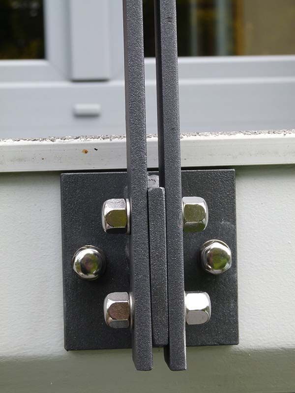 Eine Nahaufnahme eines Metallgeländers mit daran befestigten Schrauben und Muttern.