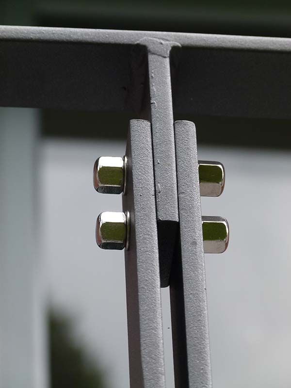 Eine Nahaufnahme von einem Metallgeländer mit Schrauben darauf