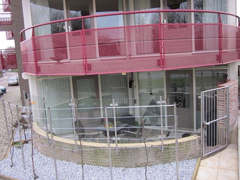 Ein Gebäude mit einem roten Geländer und einem Balkon