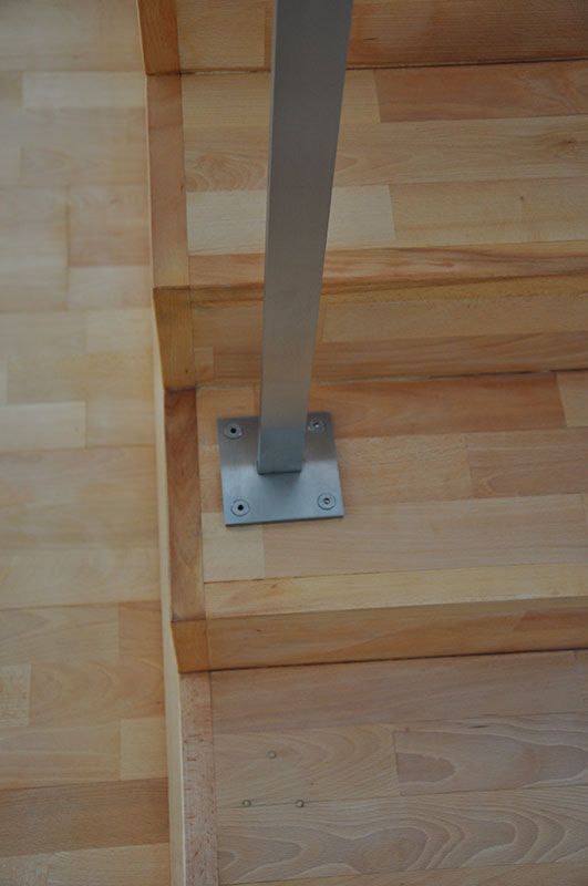 Eine Nahaufnahme einer Holztreppe mit einem Metallgeländer.